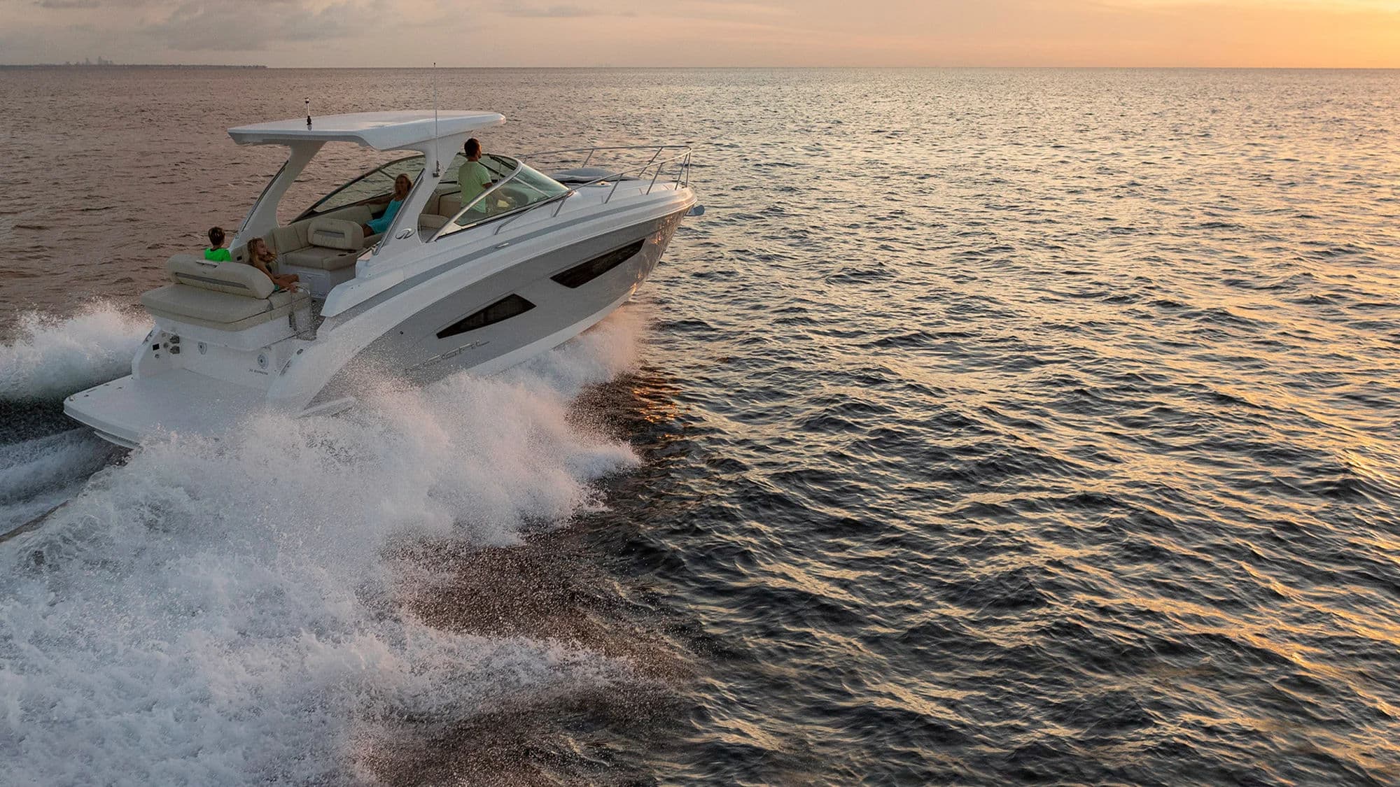 Łódź Express Cruiser płynąca o zachodzie słońca